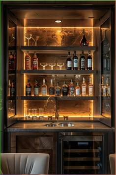 an illuminated bar with bottles and glasses on the shelves, along with a wine glass cabinet