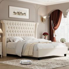 a white bed sitting in a bedroom on top of a hard wood floor next to a window