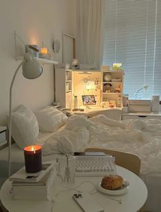 a small room with a bed, desk and laptop on the table in front of it