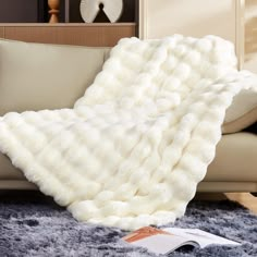 a fluffy white blanket on top of a couch