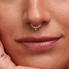 a close up of a woman's nose with a gold nose ring on it