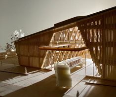 a wooden structure sitting on top of a floor next to a bench and window sill