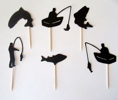 the silhouettes of various fishing related items are arranged on toothpicks to look like they were cut out of paper