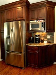 a metallic refrigerator freezer sitting inside of a kitchen next to a counter top oven