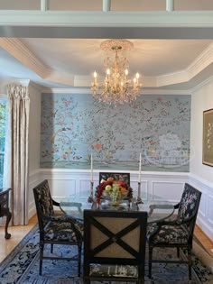 a dining room table with chairs and a chandelier hanging from it's ceiling