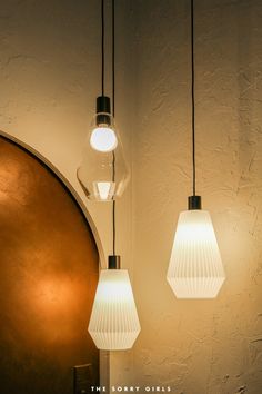 three lights hanging from the ceiling in a room