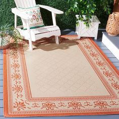 an outdoor area rug with a chair and potted plants