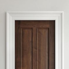 a wooden door with white trim in a room