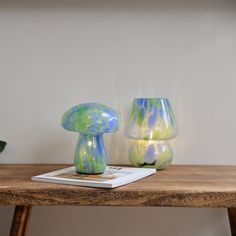 two blue and green vases sitting on top of a wooden table