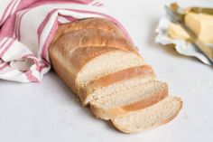 a loaf of bread sitting on top of a white counter next to a red and white towel