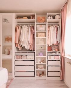 a white closet filled with lots of clothes and drawers next to a bed in a bedroom