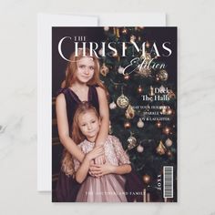 a magazine cover with two girls hugging each other in front of a christmas tree and ornaments