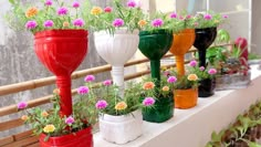 many different colored vases with flowers in them on a ledge outside the window sill