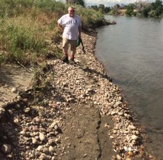 a man walking along the edge of a river