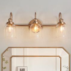 a bathroom vanity with two lights and a mirror