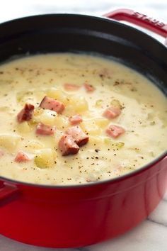 a red pot filled with soup on top of a table