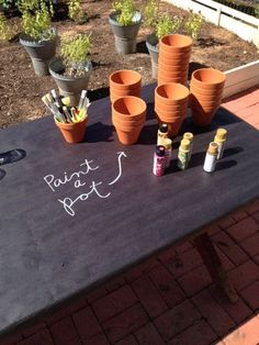 there are many pots and bottles on the table with writing written on it in white chalk