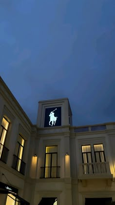 a large building with a clock on the top of it's face at night