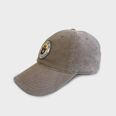 a grey hat with a brown patch on the front and side, sitting against a white background