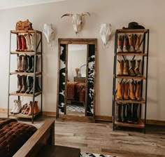 a room with several shelves and shoes on the floor in front of a large mirror