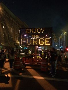 people are standing in the street near a sign that says enjoy the surge