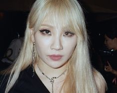 a woman with long blonde hair and piercings on her ears is posing for the camera