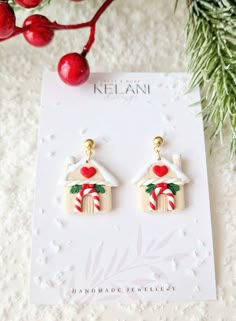 the earrings are made out of wood and decorated with candy canes, holly leaves, and a house