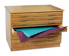 a wooden file cabinet with blue paper on top