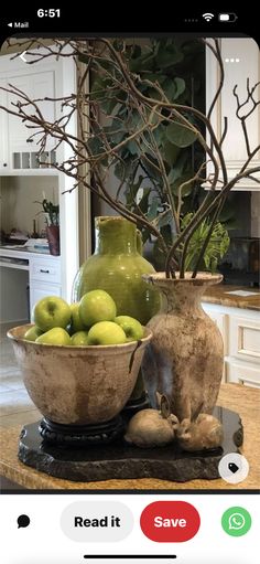 two vases filled with green apples sitting on top of a kitchen counter next to a bowl of fruit