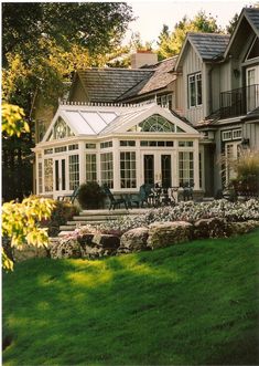 a large house sitting on top of a lush green field