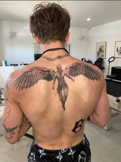 the back of a man with tattoos on his body