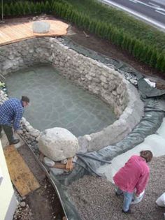 two people are working on an outdoor pond