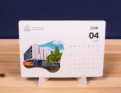 a desk calendar sitting on top of a wooden table