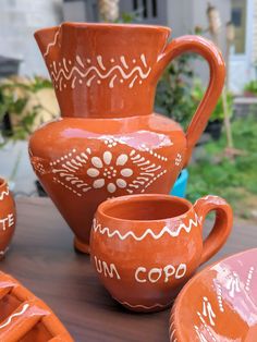 a table topped with orange and white pottery