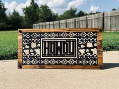 a wooden sign with the word hope in black and white designs on it, sitting outside