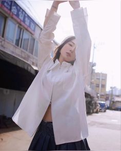 a woman standing in the street with her arms up