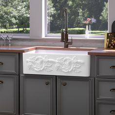 a kitchen with gray cabinets and a white sink