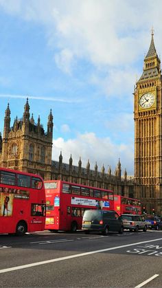 the big ben clock tower towering over the city of london and other tourist buses in traffic