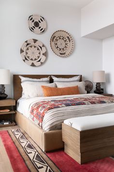 a large bed sitting in a bedroom next to two wall hangings on the wall