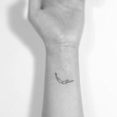 a black and white photo of a hand with a small tattoo on it's wrist