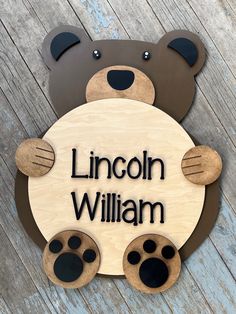 a wooden sign that says lincoln william with paw prints on the front and back of it