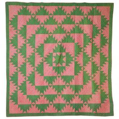 a pink and green quilt with an intricate design on the front, in square shape