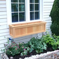 a window box filled with plants next to a house