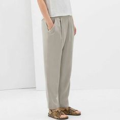 Zara Relaxed Draped Front Trousers In Sand.....Size S. Slinky Soft Weave; 100% Lyocell. Light Grayish Beige/Ivory/Stone. Crossover Draped Pleated Front. Elasticized Waistband At Back. Side Zipper Closure. Slanted Front Pockets. Relaxed Tapered Legs. Waist Across 14.25". Front Rise 10.75". Hip Across 20.75". Inseam 27.5". Leg Opening 6.25" Across. New With Tag. Versatile Gray Relaxed Fit Bottoms, Chic Gray Ankle-length Pants, Gray Straight Leg Bottoms For Spring, Chic Gray Bottoms With Elastic Waistband, Chic Gray Pants For Spring, Elegant Gray Summer Pants, Gray Straight Leg Summer Bottoms, Chic Gray Relaxed Fit Bottoms, Gray High-waisted Pants For Spring