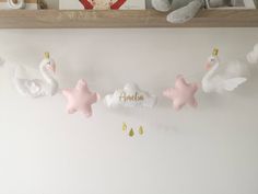 a baby's room with pink and white decorations on the shelf above it is a teddy bear