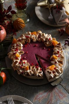 there is a cake that has been decorated with oranges and pomegranates