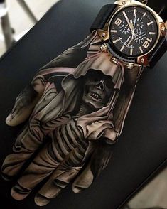 a glove with a skeleton on it sitting on top of a chair next to a watch