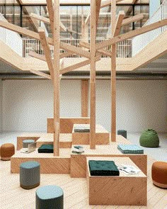 several benches and stools are arranged in the middle of an open space with wooden beams