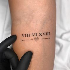 a woman's arm with roman numerals on it and a heart in the middle