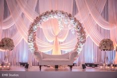 a white couch sitting under a wedding arch